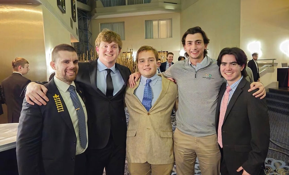 Young men in suits with their arms around each other.