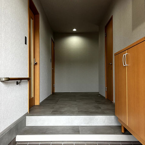 玄関エリアを撮影した施工後写真。広々とした空間に既存のキャビネットや建具を活用。