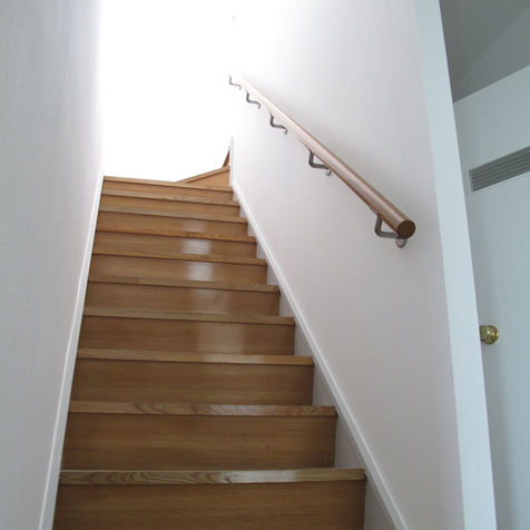 2階へ上がる木製箱型階段と手摺の写真