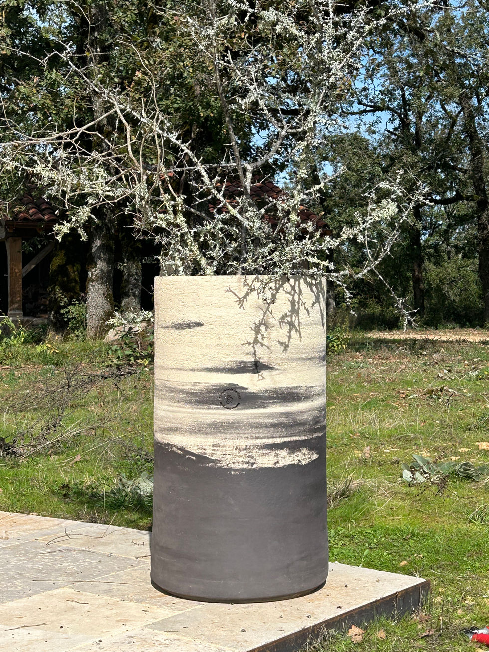 Gros pot en terre mêlée blanc et noir dans son jardin