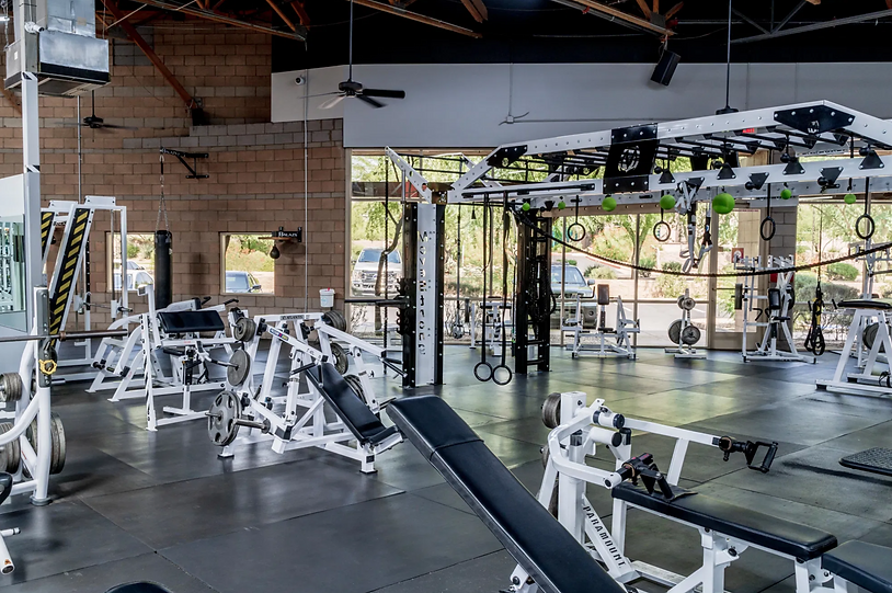 Fully equipped weight training area with free weights, squat racks, and strength machines at KC Fitness Lab in Scottsdale, AZ