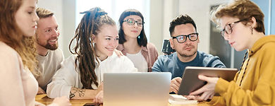 Team sitting round table looking at laptop