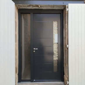 pose d une porte d entree design moderne avec une partie ajouree avec verre et un vantail fixe en verre cadre aliminium pour maison renovee a meysse en ardeche