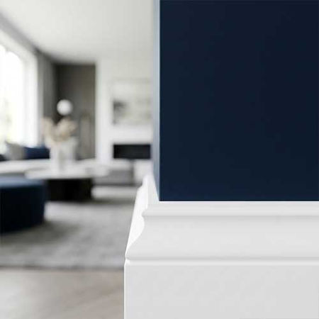 Crisp, clean contrast edge between a deep navy blue interior accent wall and a pristine white baseboard molding, highlighting precision architectural masking and premium residential interior painting by Markovich Custom Painting.
