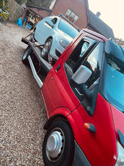 Silver car loaded onto a recovery truck for safe transport.