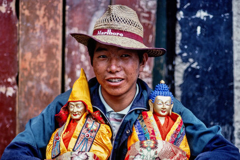 A man with his two new Buddha statues in the old town of Lhasa. Tibet, 2000.