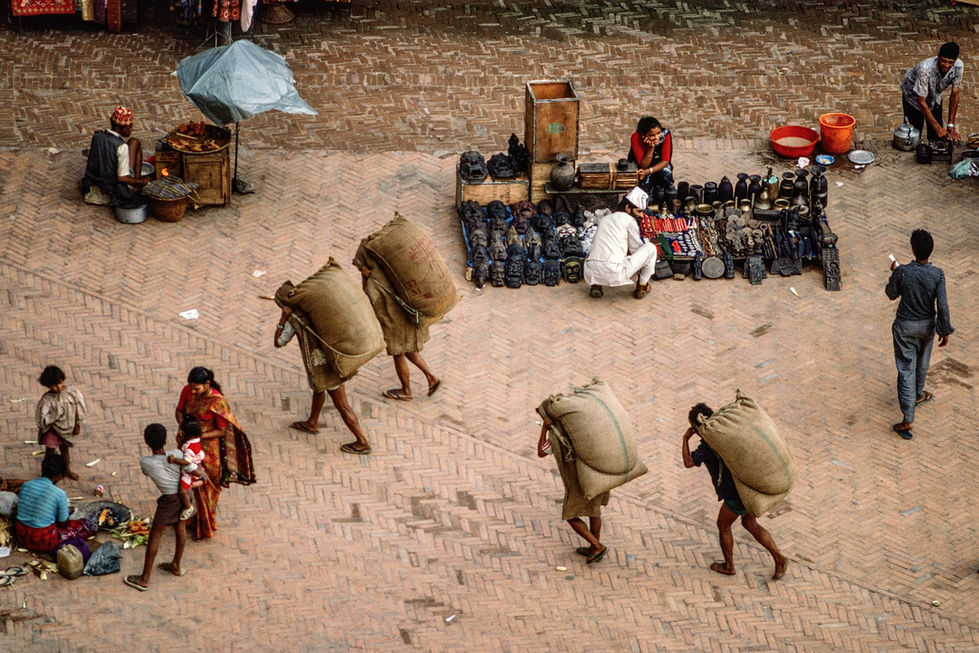 Porters carry heavy loads of farm products across the Basantapur Square in Kathmandu. Nepal, 1990.