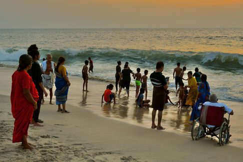 An extended family enjoys the sunset on Mararikulam beach in Kerala. India, 2024.