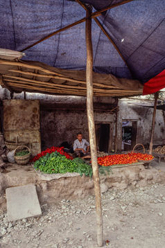A Uyghur sells chili peppers and vegetables in the old town of Kashgar. Xinjiang, 1987.