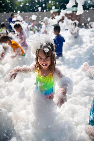 Kids enjoying a foam party in Naperville IL during a summer birthday celebration