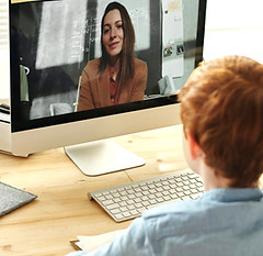 Boy on a video call with a woman on a computer screen