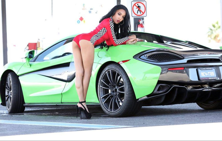 Paradise Rodriguez-Bordeaux faces the camera beside a McLaren at Exotics Racing in Las Vegas.