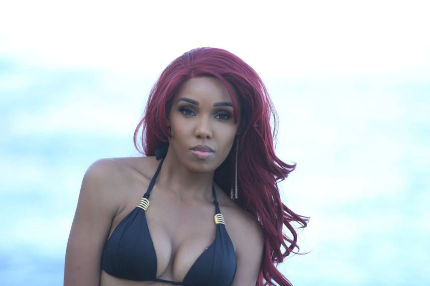 Close portrait of Paradise Rodriguez-Bordeaux in a black triangle bikini by We Party Swimwear with ocean behind her in San Diego, gold earrings, makeup by Je Suis Beauty — photography by Ron Mooney