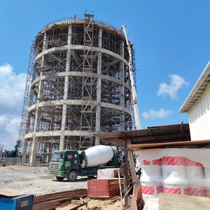 Large cylindrical structure under construction with scaffolding.