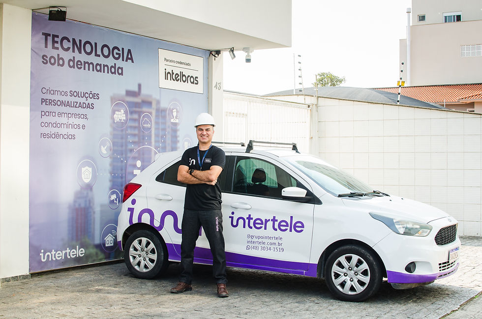 homem da intertele em frente a um carro plotado com a marca