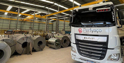 caminhao da DAF da perfyaço em um galpao com rolos de aço