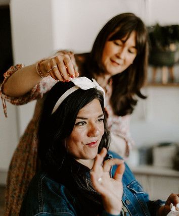 Lady having a headband placed on her head to try on with help