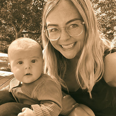 Faye, postpartum doula and mother, holding her own baby with love and calm presence