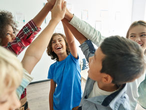 Elementary school children smiling as they high-five