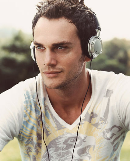White man wearing headphones with a stubble beard style