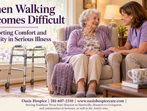An older woman seated in an armchair talks with a caregiver in a softly lit living room, with a walker nearby.