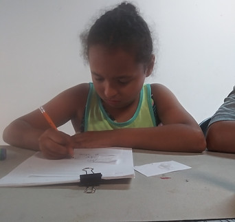 A young girl with a stack of paper-clipped papers is using a pencil as she is seemingly working on her assignments.
