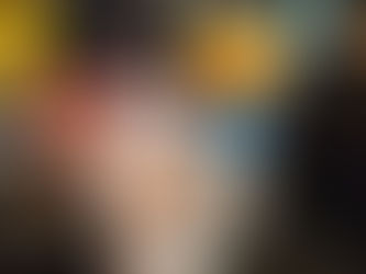 Mug of hot chocolate with a spoon on marble countertop. Nearby are cans of coconut milk, baking cocoa, and coconut palm sugar. Warm kitchen setting.