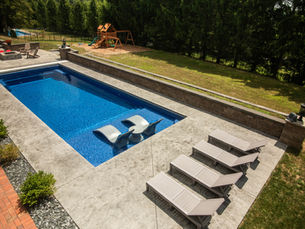 Beautiful stamped concrete pool deck with sandstone coloring and decorative border in Pittsburgh backyard