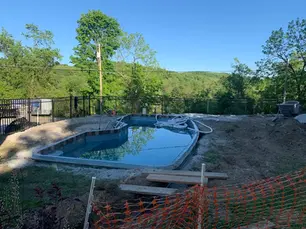 Professional contractor measuring pool deck area for installation quote in Pittsburgh PA backyard