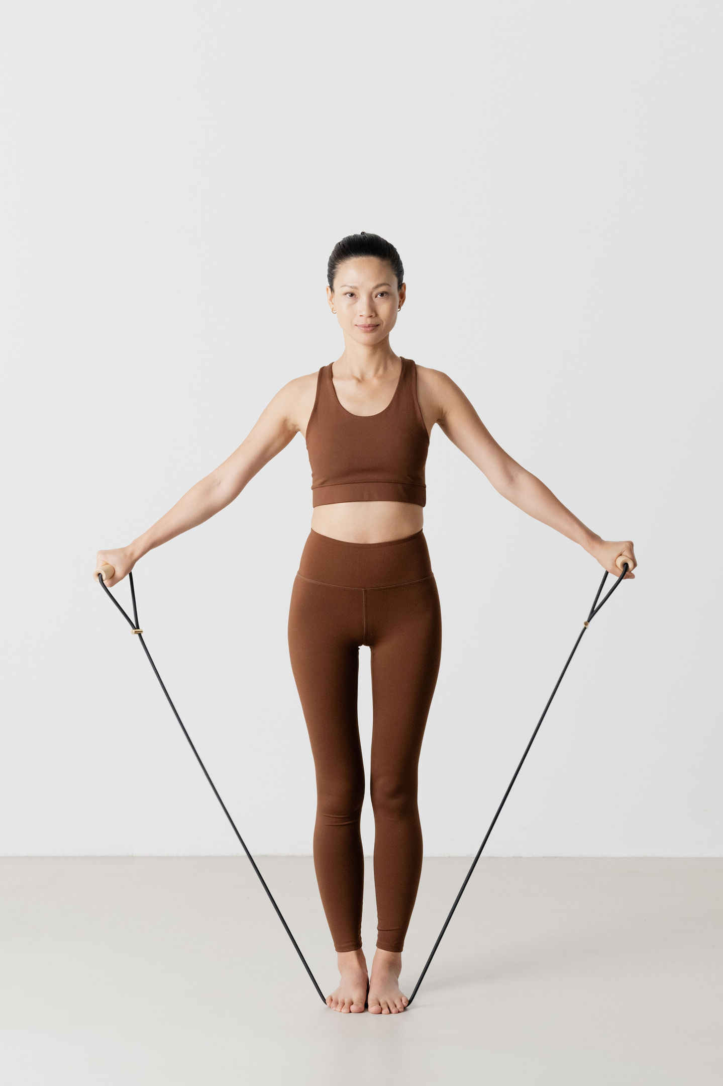 Sportlerin trainiert mit Expander Double mit Ahorn Griffen