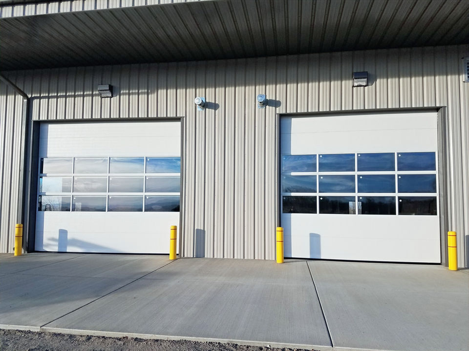 Two white Raynor Commercial Garage Doors with clear windows