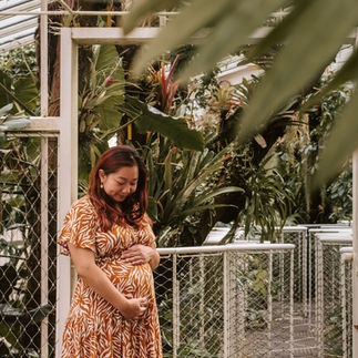 zwangere vrouw in de plantentuin van Meise wrijvend over haar zwangere buik