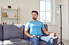 Male patient undergoing vitamin therapy. Handsome young man sitting on the sofa at home an