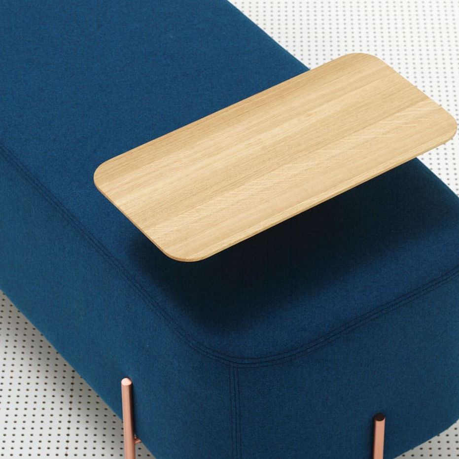Pouf design aux formes géométriques arrondies, avec pieds en finition cuivre ou graphite et tablette en chêne teinté.
