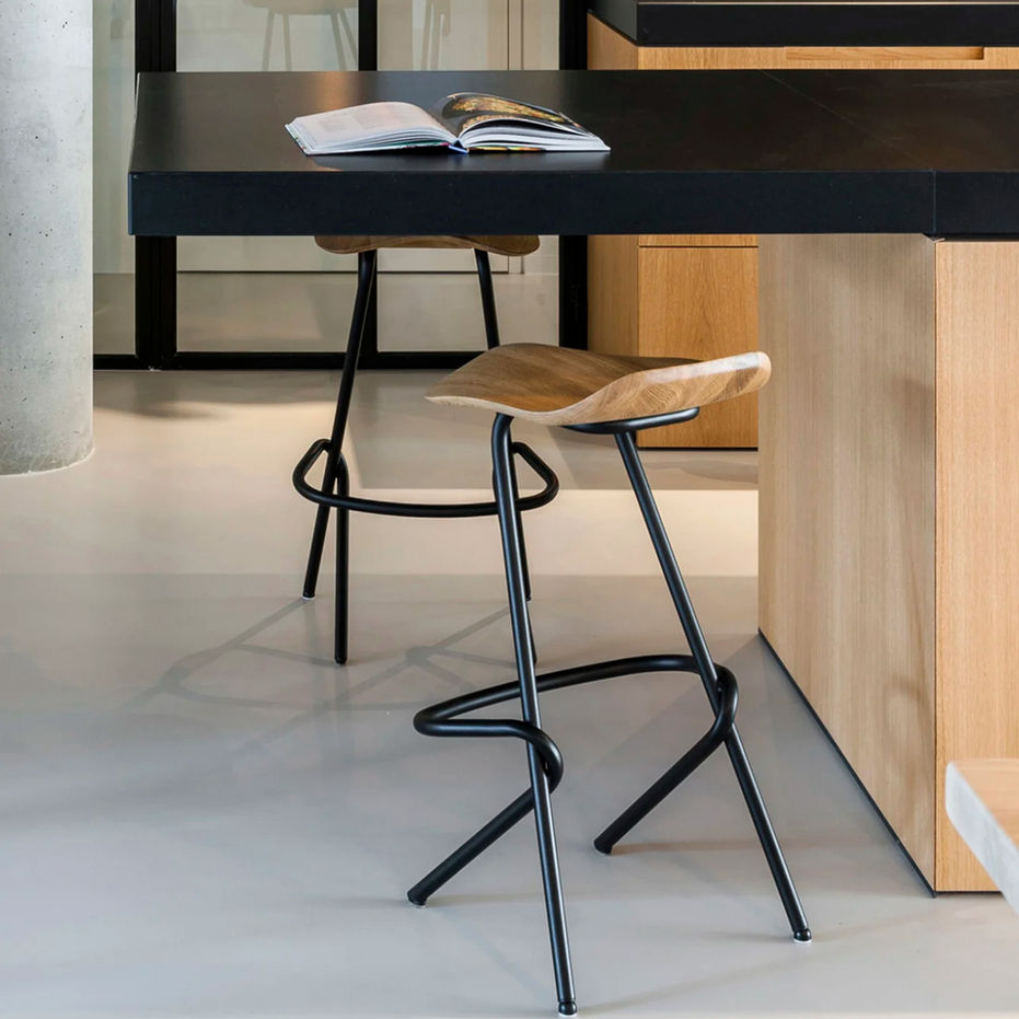 Tabouret de bar Strain avec assise sculptée en bois massif et structure en acier entrelacé