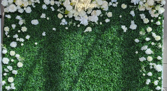 Green and white floral wall rental with "Love" sign