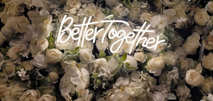 White flower wall backdrop with neon sign option.