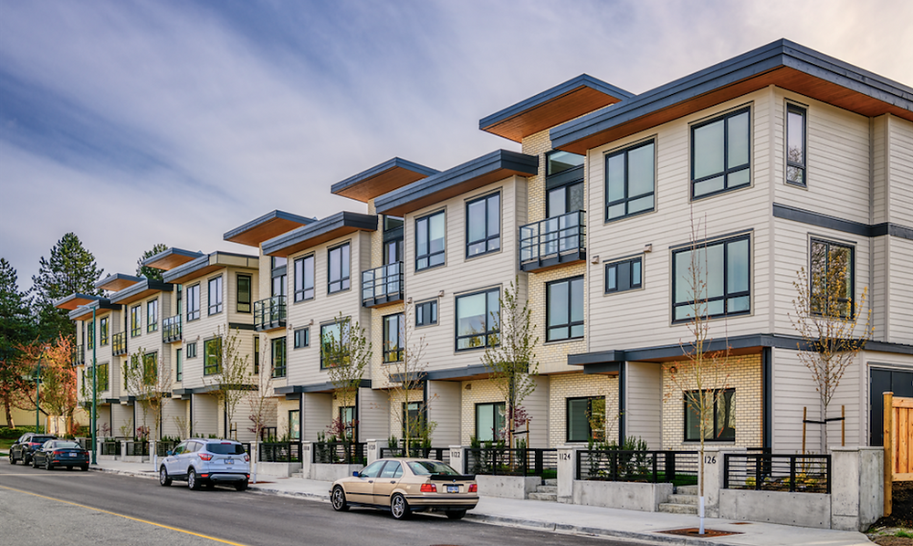 The Dwell24. Row of modern townhouses along a street with cars