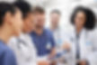Group of physicians, diverse in gender and race, consulting together.