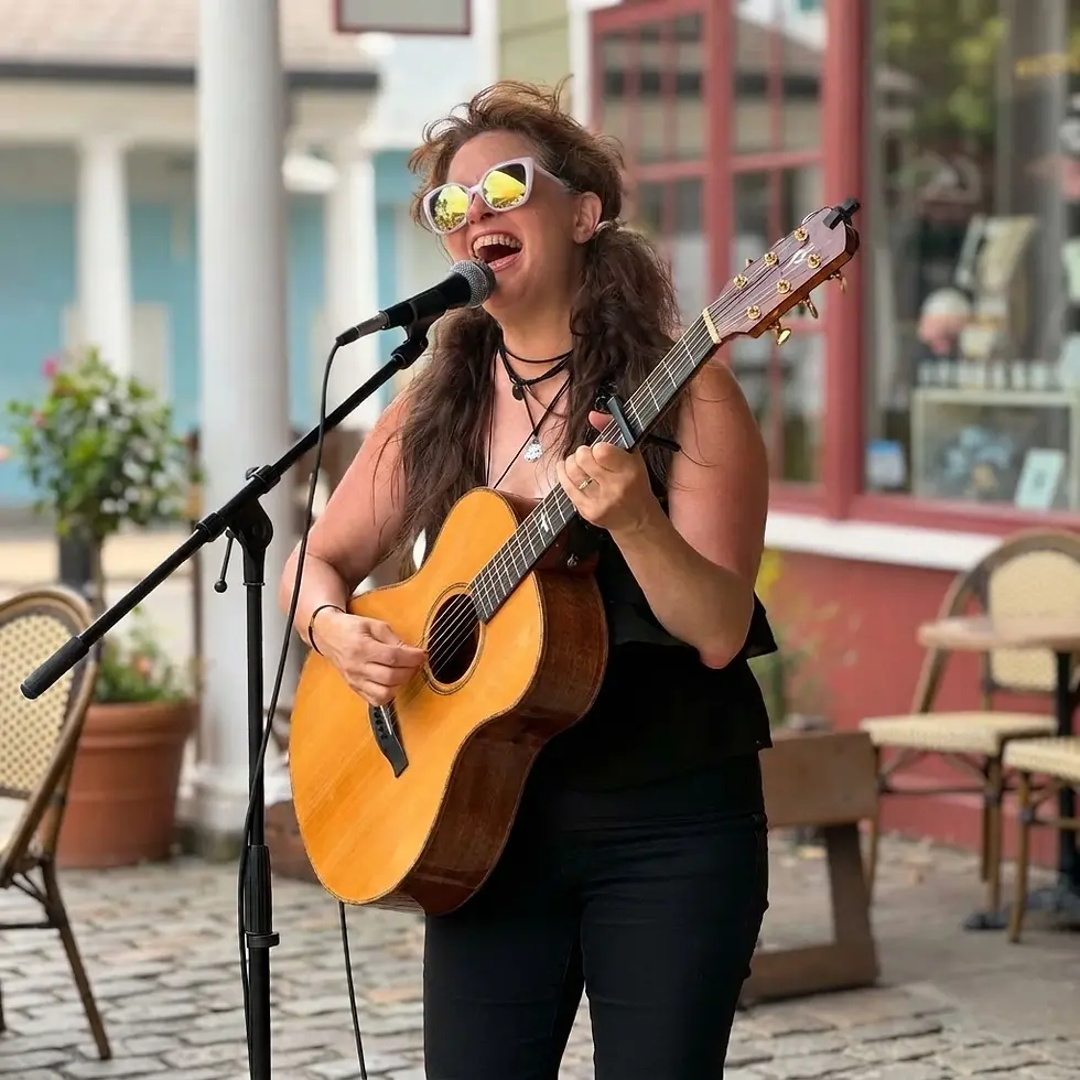 Portrait of Michelle Ingrham performing live with a guitar