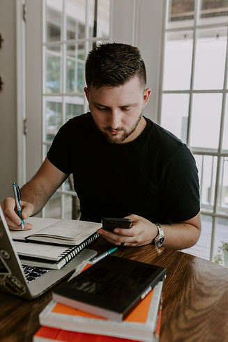 Self Portrait of Josh Holding a Phone and Sketching in a Notebook