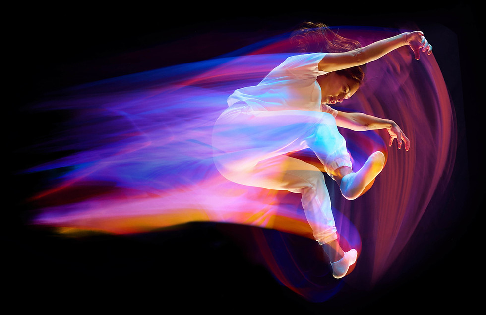 black background with pink and blue gradiant colours of a woman jumping