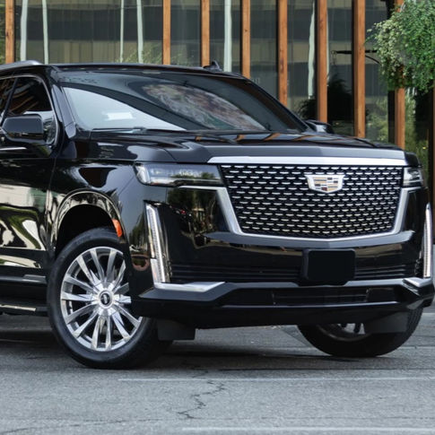 Black Cadillac Escalade parked outdoors, showcasing its bold grille, sleek design, and luxury SUV features.