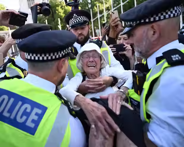A woman being arrested by 4 police officers in Parliment Square, London