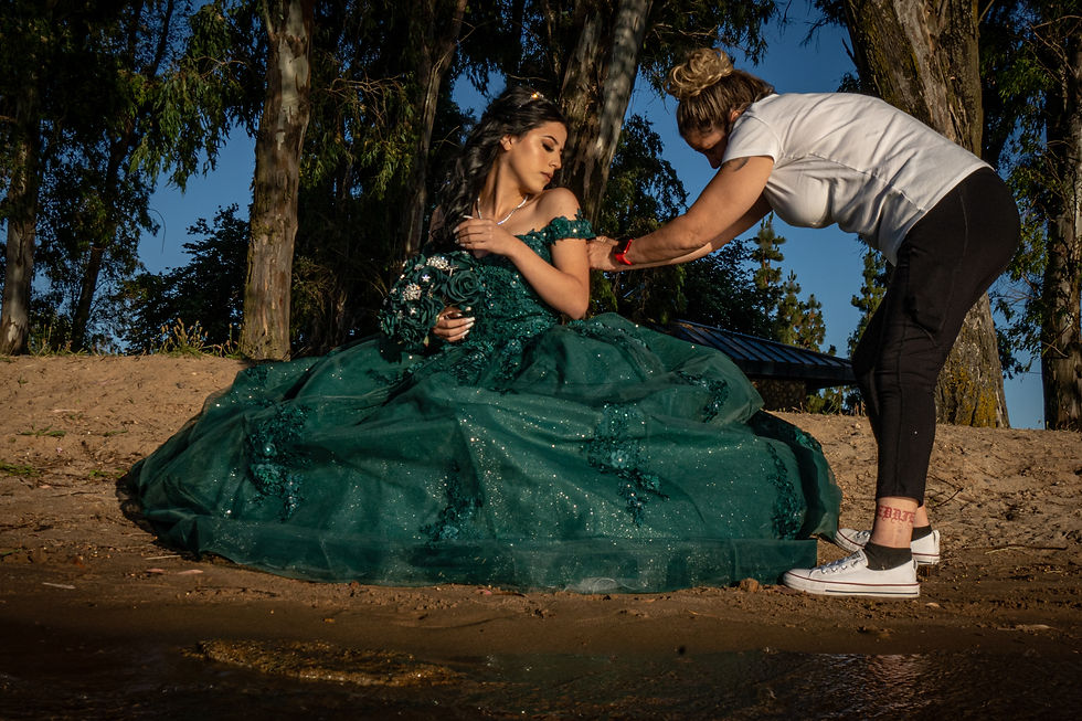 A mother delicately helps her daughter into a beautiful green Quinceañera dress at Lake Yosemite in Merced, California, radiating love and anticipation for the perfect celebration.
