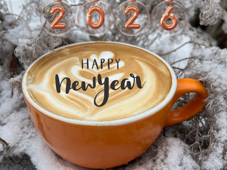 Happy New Year written on latte in orange mug.