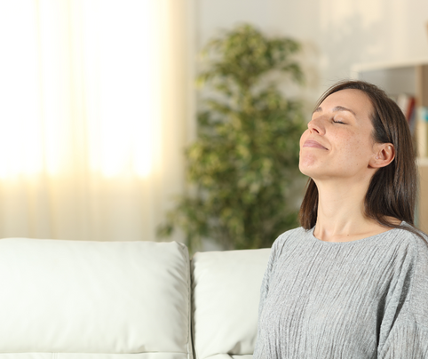 a woman breathing in deeply within her living room