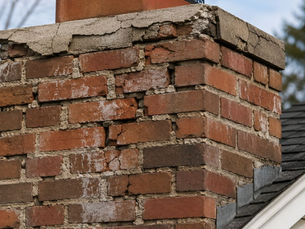 A New England chimney with loose, cracking, and spalling bricks— signs that it needs masonry repair.