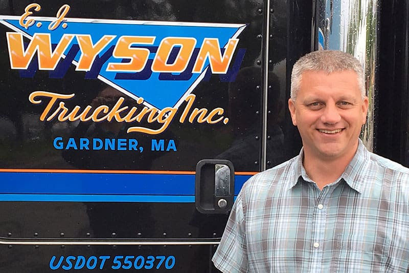 Eric Wyson stands in front of an E.J.Wyson Truck
