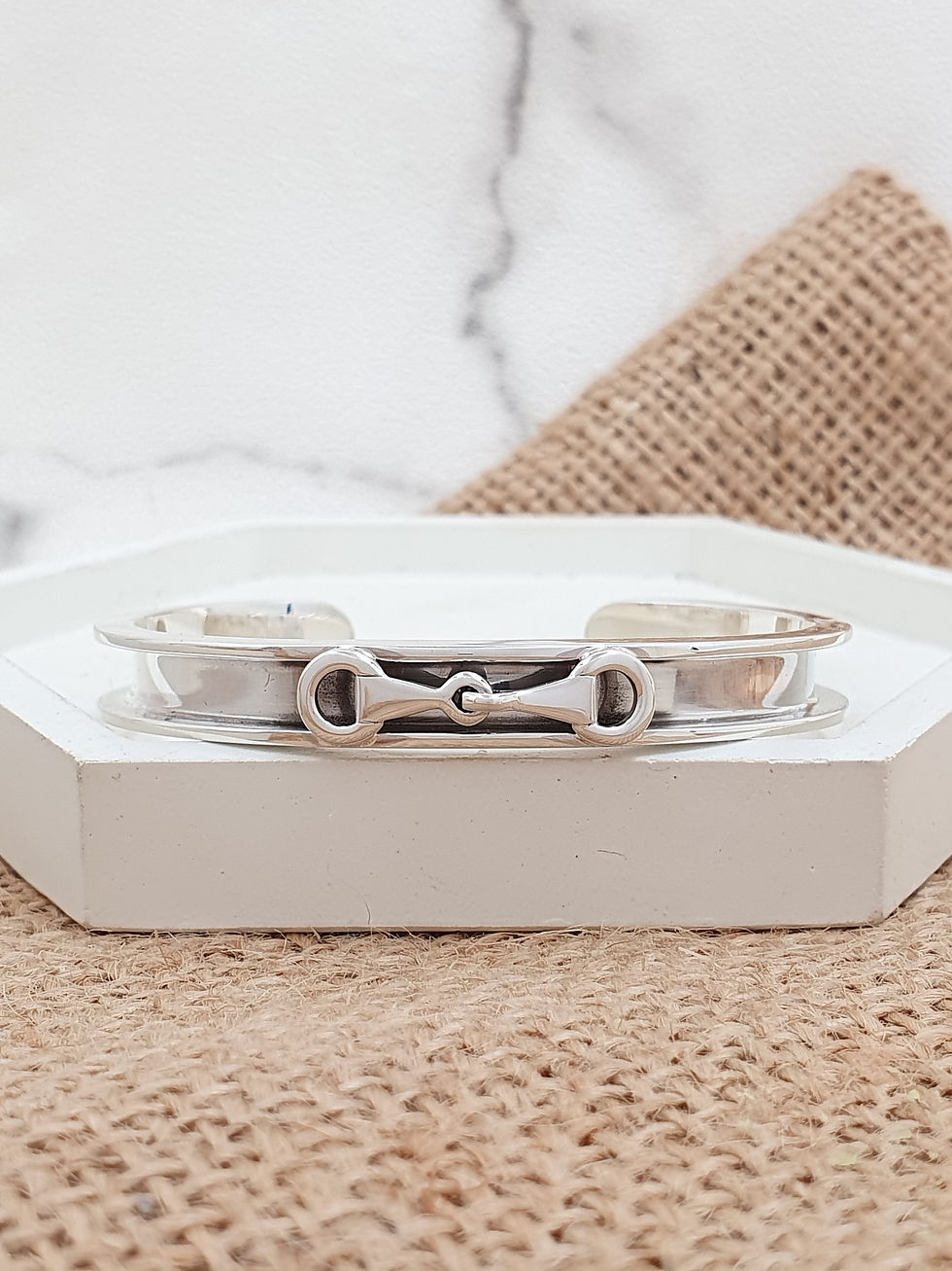 Eye-level view of a gold horseshoe bracelet on a wooden surface